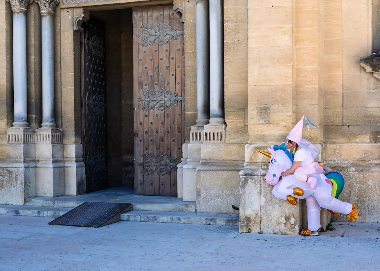 Une femme en costume gonflable de licorne arc-en-ciel